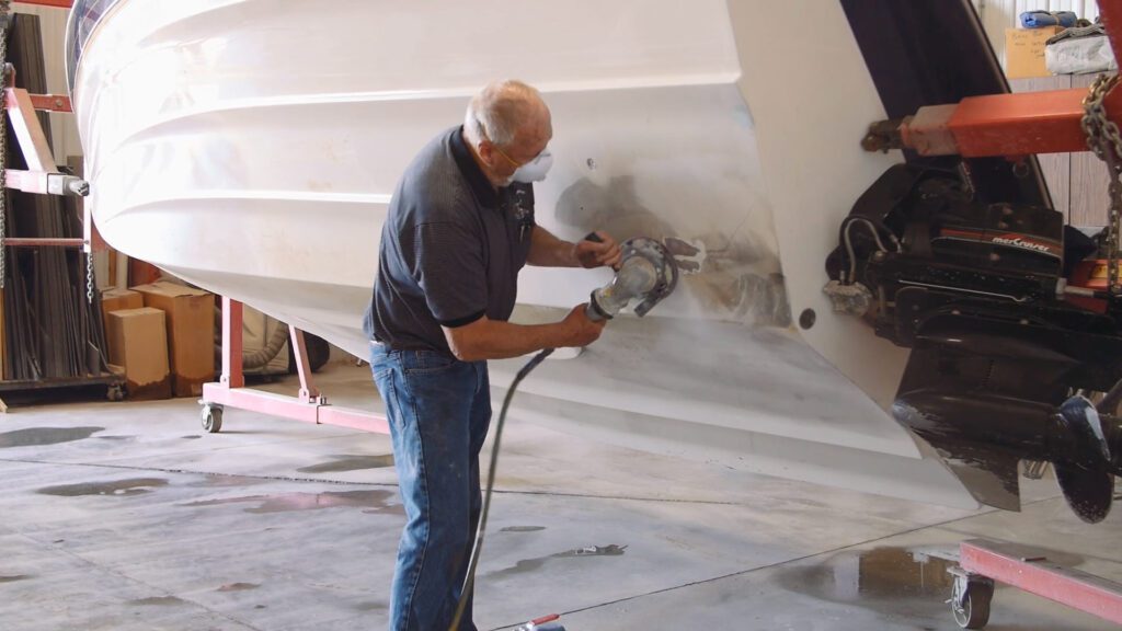 A man repairing a boat hull using the Capsizer 8000.